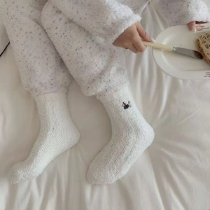 Close-up of white coral fleece socks featuring cute animal embroidery for winter comfort