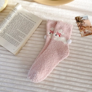 Detail of pink coral fleece thermal socks featuring a 3D pom-pom and cute rabbit embroidery