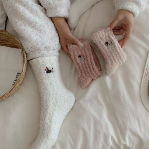 Close-up of soft coral fleece winter socks with cute dachshund embroidery in pink and white