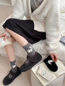 Détail de chaussettes en laine avec motif jacquard chat et petits nœuds bleus doux