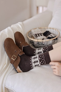 Close-up of vintage Fair Isle knit wool socks paired with warm brown suede mule shoes