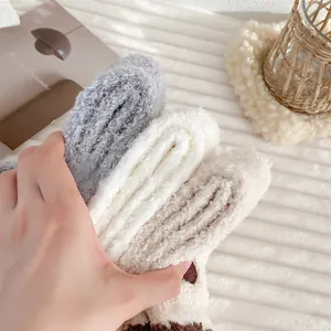 Detailed close-up of fluffy coral fleece winter socks in grey, white, and khaki colors