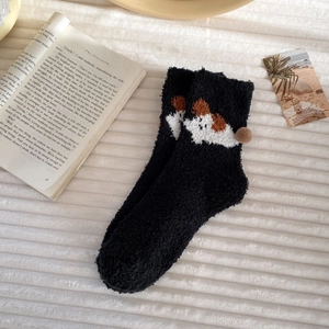 Detail of coral fleece winter sock featuring a 3D plush ball and cartoon puppy pattern