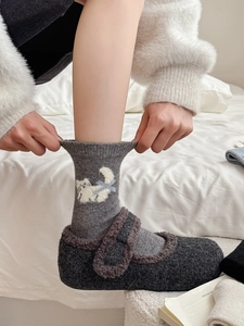Gros plan de chaussettes en laine avec chat et pantoufles Mary Jane en peluche