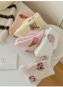 Detailed view of assorted coral fleece socks with cute patterns and plush soft texture