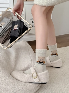 Détail de chaussettes en laine avec broderie ours en beige, gris et noir