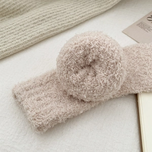 Close-up of soft coral fleece texture on a warm pink plush lounge accessory for home