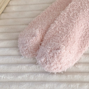 Close-up detail of soft pink coral fleece socks with thick fluffy winter texture