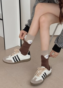 Detail of dog embroidery and purple bow on color-block cotton mid-calf socks