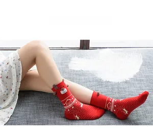 Detail of red Christmas socks with reindeer motifs and 3D ears shown on model