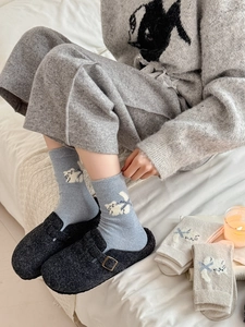 Détail de chaussettes en laine avec motifs de chat blanc et poignets côtelés doux