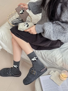 Dettaglio di calze di lana invernali spesse con motivi a maglia di panda in vari colori