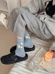 Détail de chaussettes épaisses en tricot de laine avec broderie de chat bleu et beige