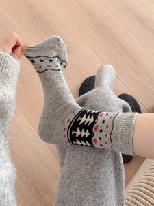 Detailed knit texture of wool socks featuring festive patterns on light gray fabric
