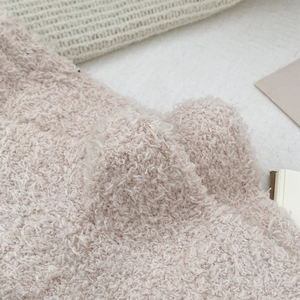 Detailed macro view of soft beige coral fleece texture on cozy dachshund winter socks