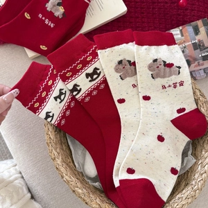 Detailed knit texture of red and beige New Year socks with horse motifs and patterns