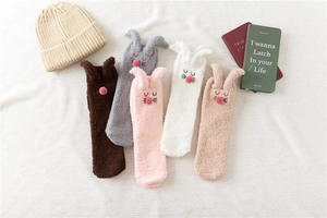 Detailed flat lay of soft coral fleece bunny slippers socks and matching knitted beanie set