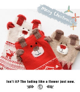 Detailed close-up of knit Christmas socks with plush 3D reindeer ears and snowflake patterns