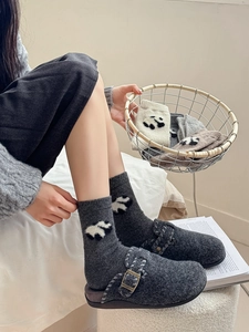 Dettaglio di calze di lana con jacquard panda e sabot in feltro per il calore invernale
