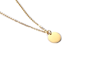 Macro view of polished gold stainless steel coin pendant on a fine link chain