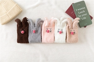 Detail of five colors of coral fleece rabbit socks with 3D ears and plush noses
