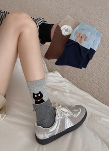 Detailed close-up of cute animal embroidery and ribbed cuffs on cotton mid-calf socks