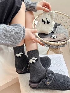 Trama dettagliata in maglia di calze di lana con motivo panda e pantofole in feltro