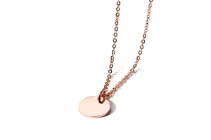 Detailed view of polished rose gold coin pendant on a delicate cable chain link