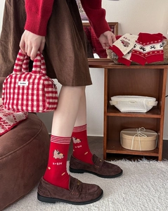 Detail of red combed cotton socks with alpaca embroidery and plaid plush tote bag