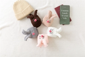 Flat lay of five colorful thick coral fleece rabbit slippers socks with plush 3D ears