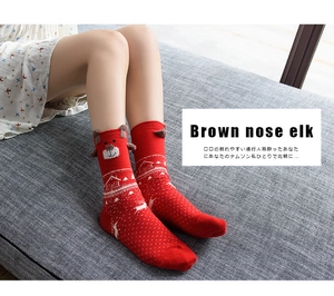 Detail of red Christmas socks with 3D reindeer ears and festive snowflake patterns