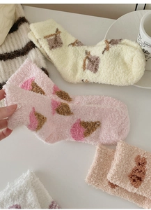 Close-up of thick coral fleece socks with cute ice cream embroidery in macaron colors