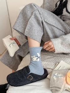 Détail de chaussettes en laine tricotée avec motif jacquard chat et ruban bleu