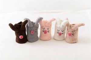 Detail of coral fleece slipper socks featuring cute rabbit ears and embroidered faces