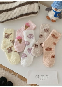 Close-up of five pairs of thick coral fleece winter socks with cute dessert patterns