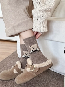 Gros plan de chaussettes en laine d'hiver avec broderie ours et chaussons en polaire