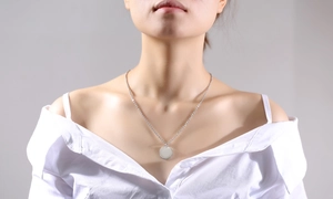 Polished minimalist gold coin pendant necklace on model with refined mirror finish