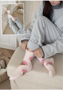 Close-up of soft pink coral fleece socks featuring brown and red ice cream patterns
