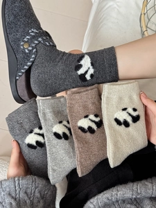 Dettaglio della maglia dei calzini in lana con panda in vari colori invernali