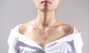 Detailed view of polished rose gold coin pendant necklace on female model neck