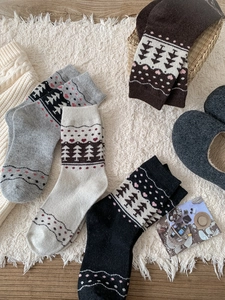 Detailed close-up of thick winter wool socks with Nordic Fair Isle patterns on cozy carpet
