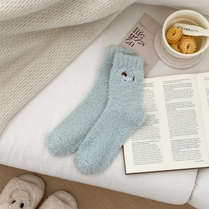 Cosy blue coral fleece dachshund socks presented with books and home accessories