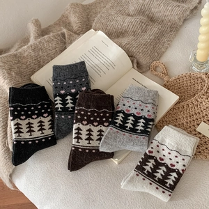 Detailed knit texture of five pairs of Nordic Fair Isle wool socks in neutral tones