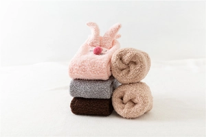 Close-up of fluffy coral fleece socks with 3D bunny ears in various winter colors