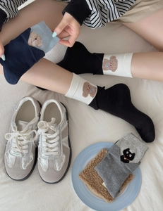 Close-up of cute cartoon animal embroidery and ribbed cuffs on cotton mid-calf socks