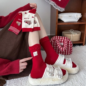 Detail of red festive crew socks with ruffle cuffs and cute horse embroidery pattern