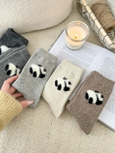 Dettaglio di quattro paia di calze di lana invernali con jacquard panda e decoro accogliente