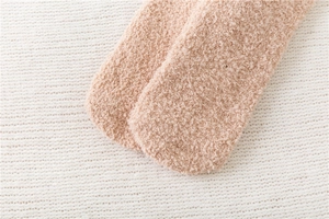 Close-up of thick coral fleece rabbit socks showing plush texture and warm material