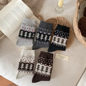 Close-up of five pairs of thick Fair Isle wool socks with pine and heart patterns