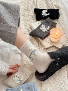 Détail de chaussettes en laine chaudes avec broderie chat mignonne et bords-côtes doux colorés